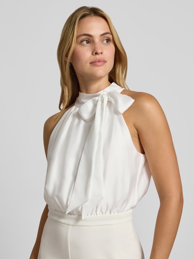 Frauenmodel trägt Jumpsuit mit Stehkragen von SWING in Creme, taillierte Passform, Zierschleife, ärmellos, Nahaufnahme Oberkörper.
