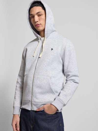 Männermodel trägt Slim Fit Sweatjacke mit Label-Stitching von REVIEW, hellgrau, Känguru-Tasche, Baumwoll-Mix, Ganzkörperansicht von vorne.