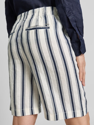 Frauenmodel trägt Bermudas aus Leinen im Allover-Look von Christian Berg Woman, creme mit dunkelblauen Streifen, Regular-Fit, Detailaufnahme Rückansicht.