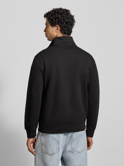 Męski model nosi Sweatshirt mit Label-Detail od Levi's®, czarny kolor, bawełna, regular fit, widok całej sylwetki z tyłu.