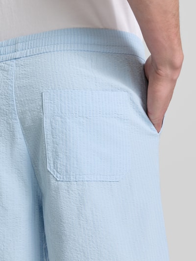 Männermodel trägt hellblaue Regular Fit Shorts aus reiner Baumwolle Modell 'STUART' von SELECTED HOMME, Seersucker-Textur, Detailaufnahme