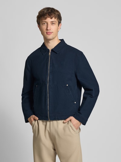 Männermodel trägt Regular Fit Übergangsjacke in Denim-Optik von REVIEW, Dunkelblau, Reine Baumwolle, Umlegekragen, Reißverschluss, Kängurutasche, Ganzkörperansicht von vorne.