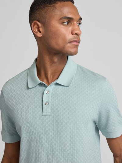 Männermodel trägt mintgrünes Poloshirt mit kurzer Knopfleiste Modell 'Roni' von JOOP! Collection, Nahaufnahme Oberkörper.