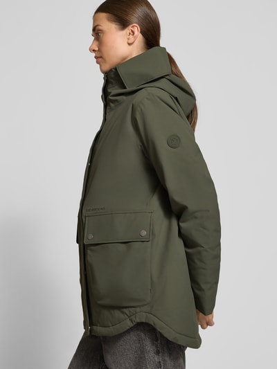 Vrouwenmodel draagt Didriksons Jacke mit 10.000 mm Wassersäule Modell 'DANIELLA', olijfgroen, regular fit, winddicht, waterdicht, ademend, met patzakken, Thermore voering, zijaanzicht, detailopname van het bovenlichaam