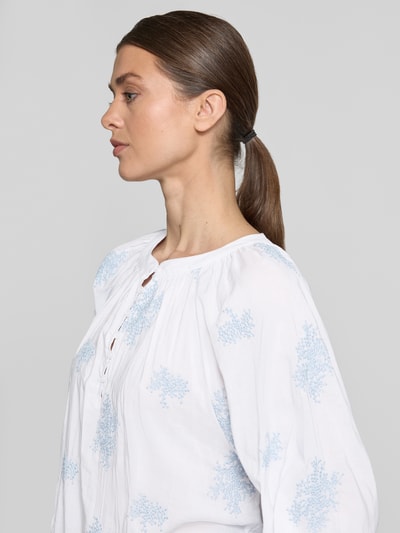 Frauenmodel trägt Bluse aus Viskose-Mix mit verlängertem Rücken von Apricot, Weiß mit blauem Muster, Rundhalsausschnitt, Knopfleiste, Viskose-Baumwoll-Mix, Loose-Fit, Rückenlänge 68 cm, Ärmellänge 52 cm, Nahaufnahme Oberkörper