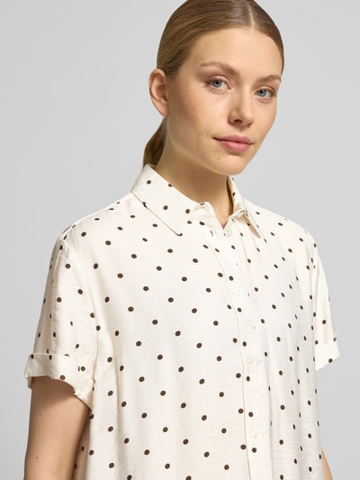 Kobiece model prezentuje Regular Fit Bluse aus Viskose-Mix im Allover-Look od Jake*s Casual, biała w czarne kropki, kołnierzyk koszulowy, rękawy z mankietem, krój regular fit, miks wiskozy, widok z przodu, zbliżenie na górną część ciała.