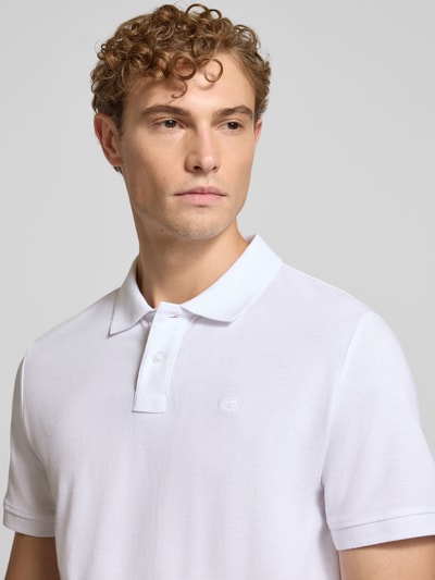 Mężczyznę model nosi Regular Fit Poloshirt aus Baumwoll-Mix von Tom Tailor w kolorze białym, gładka tekstura, Nahaufnahme Oberkörper. Koszulka polo męska od Tom Tailor.