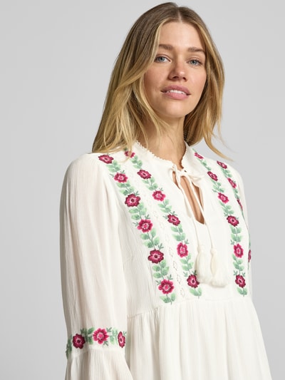 Frauenmodel trägt Regular Fit Tunikabluse aus Reine Viskose von YAS mit Stickereien, Schnürung, weiße und pinke Farben, Nahaufnahme Oberkörper.
