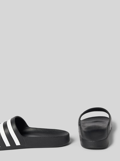 Productfoto, zwarte Badeschuhe mit Kontraststreifen Model 'ADILETTE AQUA' van adidas Sportswear, all-over motief, gestreept, afgeronde punt, plat, comfortmodel/open, gestructureerde zool.