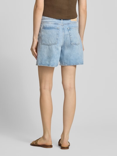 Frauenmodel trägt Shorts in Denim-Optik Modell 'Seville' von JJXX aus reiner Baumwolle, 5-Pocket-Design, Rückansicht Ganzkörperansicht.