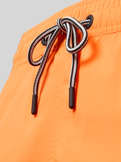 Produktfoto, orangefarbene Straight Fit Badeshorts mit Tunnelzug, elastischer Bund, Eingrifftaschen, von FIRE + ICE, glatte Textur.