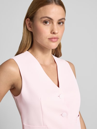 Frauenmodel trägt Satinshirt mit Rundhalsausschnitt von Rinascimento in zartem Rosa, glatte Satinstruktur, Nahaufnahme Oberkörper.