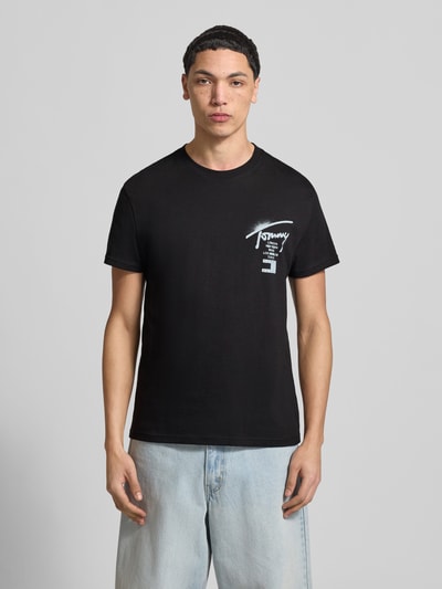 Männermodel trägt Regular Fit T-Shirt aus reiner Baumwolle von Tommy Jeans in Optik: Unifarben mit Label-Print, Ganzkörperansicht von vorne.