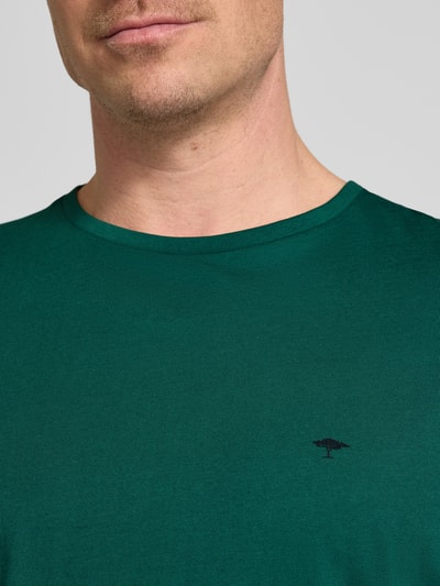 Männermodel trägt T-Shirt mit Rundhalsausschnitt und Label-Stitching von Fynch-Hatton in Grün, Reine Baumwolle, Regular-Fit, Nahaufnahme Oberkörper. Rückenlänge bei Größe M: 71 cm.