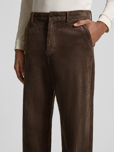 Männermodel trägt High Waist Cordhose mit Bundfalte Modell 'Luke' von Selected, unifarbene Optik, Gürtelschlaufen, Bundfalte, Knopf- und Reißverschluss, seitliche Eingrifftaschen, Gesäßtaschen, krój regular fit, Nahaufnahme Oberkörper.