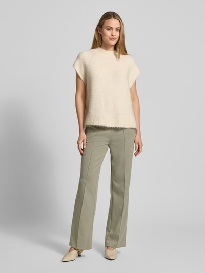 Frauenmodel trägt Stoffhose mit elastischem Logo-Bund von monari in hellem Beige, lockerer Schnitt, Material-Mix, Ganzkörperansicht von vorne.