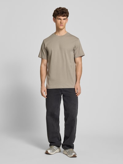 Männermodel trägt T-Shirt aus Baumwolle mit Rundhalsausschnitt von G-Star Raw, sandfarben, Regular Fit, glatte Textur, Ganzkörperansicht von vorne.