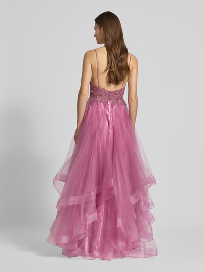Frauenmodel trägt Abendkleid mit Ziersteinbesatz von Mascara in Pink mit Spaghettiträgern, ausgestelltem Tüll-Rockteil, Maxilänge, taillierte Passform, Nahtreißverschluss, Rückenlänge 153 cm bei Größe 36, Rückenansicht Ganzkörperansicht.