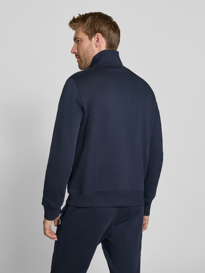 Männermodel trägt Regular Fit Sweatjacke aus Baumwolle von Paul Smith, dunkelblau, glatte Struktur, Stehkragen, Rückansicht, Ganzkörperansicht Rückansicht, Herren Sweatjacke, elastische Abschlüsse, seitliche Eingrifftaschen, Label-Stitching.