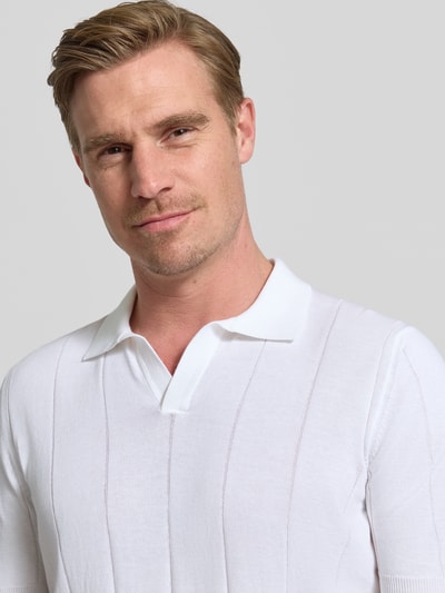 Männermodel trägt Regular Fit Poloshirt mit breiter Rippe und V-Ausschnitt von GRAN SASSO aus reiner Baumwolle, Nahaufnahme Oberkörper.