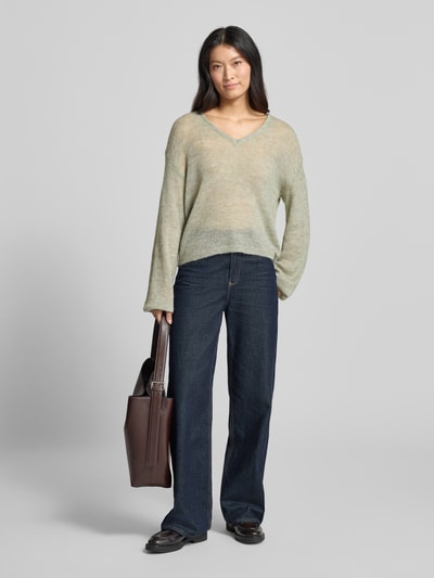 Vrouwenmodel draagt Relaxed Fit pullover met alpaca-aandeel Model 'Dido' van FREE/QUENT, mix van katoen en alpacawol, V-hals, semi-transparante look, ruglengte maat S 56 cm, mouwlengte 55 cm, volledig lichaam vooraanzicht.