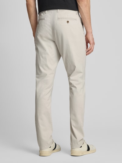 Männermodel trägt Slim Fit Chino mit Eingrifftaschen von GAP aus Baumwoll-Elasthan-Mix in Beige, Ganzkörperansicht Rückansicht. Bundweite 44 cm, Innenbeinlänge 82 cm, Knopf-Reißverschluss, abgebildete Größe 32/32.