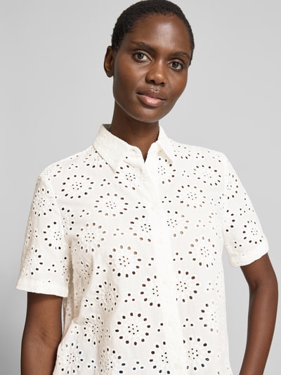 Frauenmodel trägt Regular Fit Bluse aus reiner Baumwolle mit Lochstickerei von Brax in Weiß, Lochstrick-Optik, Hemdblusenkragen, einreihige Knopfleiste, Kurzarm, reine Baumwolle, Nahaufnahme Oberkörper.