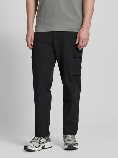 Männermodel trägt Relaxed Fit Cargohose mit Gürtelschlaufen Modell 'SRACKY' von BOSS Orange, Optik: Unifarben, Label-Patch, Passform: Relaxed-Fit, Knopf und verdeckter Reißverschluss, seitliche Eingrifftaschen, Cargotaschen, Gesäßtaschen, Ganzkörperansicht von vorne.