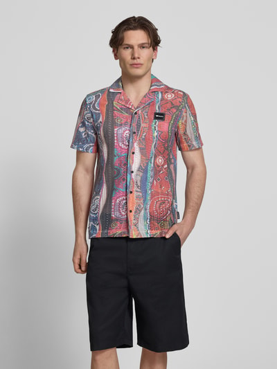 Męski model nosi Slim Fit Freizeithemd in Strick-Optik Modell 'resort' od COLUCCI, kolorowy wzór, kołnierz rewers, krój slim fit, materiał z bawełną, krótki rękaw, guziki, długość tyłu 71 cm, szerokość w rozmiarze M 46 cm, długość rękawa 11 cm, widok całej sylwetki z przodu.