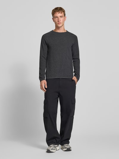Männermodel trägt Regular Fit Pullover aus reiner Baumwolle Modell 'Hill' von JACK & JONES, Strick-Optik, Ganzkörperansicht von vorne.