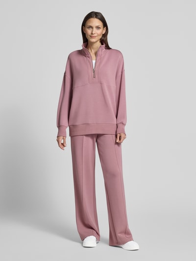 Frauenmodel trägt Wide-Leg-Pants mit französischen Eingrifftaschen von VARLEY aus Viskose-Mix mit Stretch-Anteil in Rosé, Ganzkörperansicht von vorne.