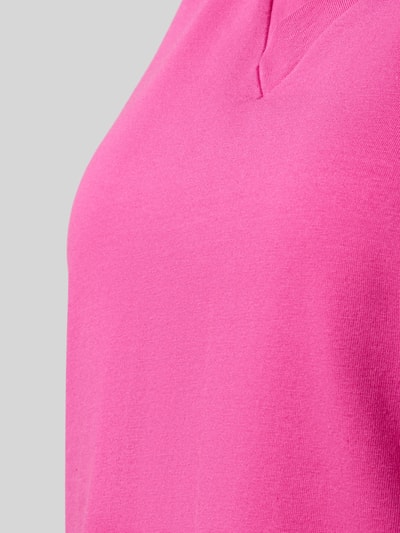 Vrouwenmodel draagt Regular Fit T-shirt met V-hals van Schiesser in felroze, katoenmix, met korte mouwen, detailopname bovenlichaam.