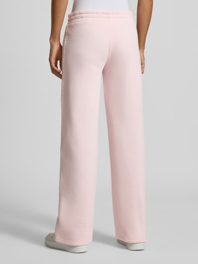 Frauenmodel trägt Wide Fit Sweatpants aus Baumwoll-Mix von REVIEW in Rosa, mit elastischem Bund und Bordüre, Ganzkörperansicht Rückansicht.