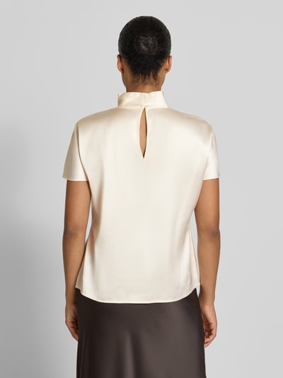 Frauenmodel trägt T-Shirt aus Viskose-Mix mit Stehkragen von Stefanel, cremefarbene Satin-Oberfläche, lockere Passform, Ganzkörperansicht Rückansicht. Damen T-Shirt mit Baumwoll-Anteil, Rückenlänge bei Größe S 59 cm.