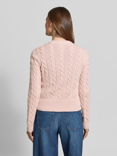 Modelka nosi Kardigan rozpinany ze ściegiem warkoczowym i okrągłym dekoltem od JAKE*S STUDIO WOMAN, bawełna, krój slim fit, długość tyłu 52 cm, długość rękawa 67 cm, jasnoróżowy, widok całej sylwetki z tyłu.