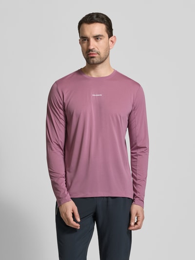 Männermodel trägt Funktionsshirt mit Logo und Rundhalsausschnitt von Salomon in regular fit, langärmelig, mauve, gladde textuur, ruglengte maat M 70 cm, Ganzkörperansicht von vorne.