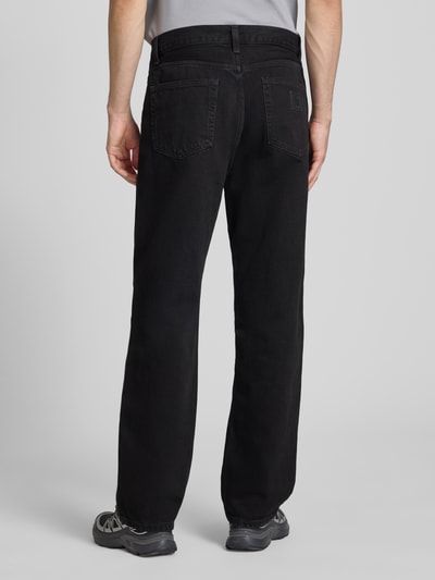 Männermodel trägt Wide Fit Jeans im 5-Pocket-Design Modell 'Aaron' von Carhartt Work In Progress, reine Baumwolle, Ganzkörperansicht Rückansicht.