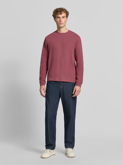 Männermodel trägt Regular Fit Langarmshirt aus Baumwoll-Mix Modell 'WE-TEMPEST' von BOSS Orange in uni Rot, Feinripp, Ganzkörperansicht von vorne.