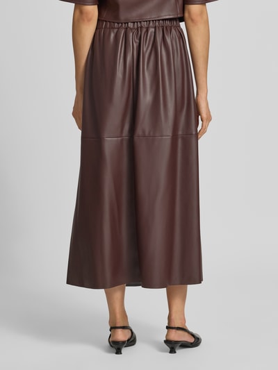 Vrouwenmodel draagt Midirok in Leerlook van Vera Mont, dames midirok in A-lijn met onderrok en deels elastische band, totaalbeeld achteraan