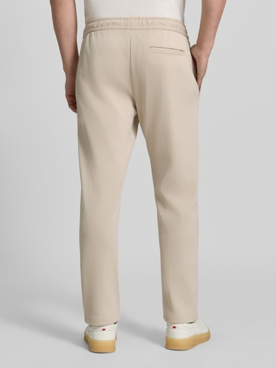 Männermodel trägt Straight Fit Hose mit Baumwoll-Anteil Modell 'Parker' von MCNEAL in Beige, elastischer Bund, Gesäßtasche, Ganzkörperansicht Rückansicht