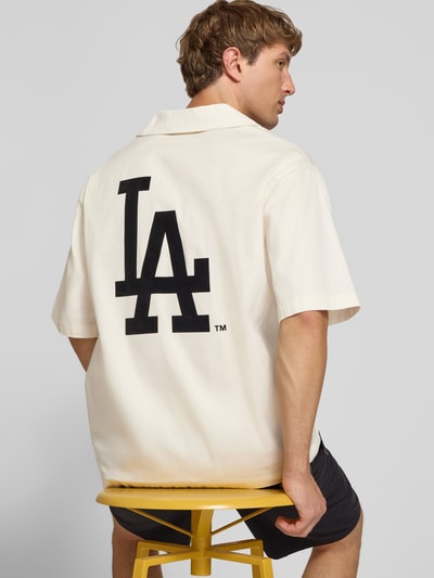 Männermodel trägt Relaxed Fit Freizeithemd aus Baumwoll-Mix von Champion in Beige mit großem LA-Print, Rückenansicht, Nahaufnahme Oberkörper.