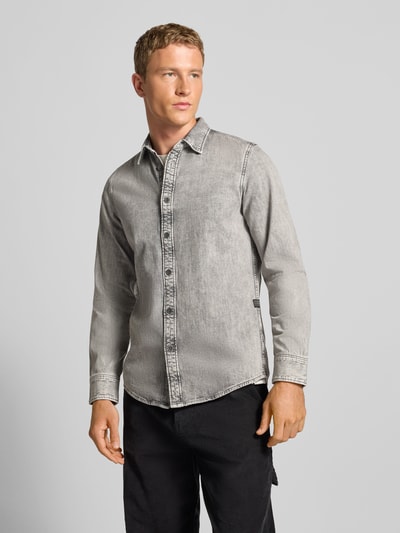 Męski model nosi Freizeithemd mit Knopfleiste od G-Star Raw, szara bawełna, slim fit, kołnierzyk kent, guziki, widok całej sylwetki z przodu.