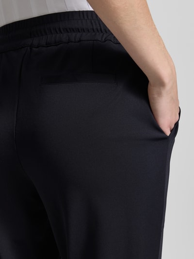Frauenmodel trägt Jogpants mit elastischem Bund Modell 'Jill' von monari, dunkler Material-Mix mit Stretch-Anteil, Regular-Fit, Detailaufnahme Rückansicht
