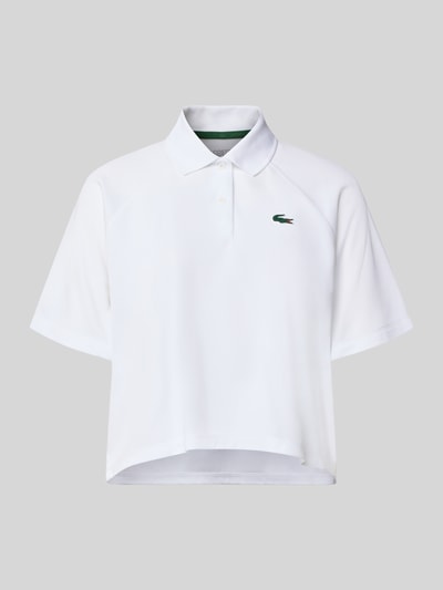 Produktfoto, weißes Relaxed Fit Sport-Poloshirt mit Logo-Patch von Lacoste für Damen, glatte Textur vor grauem Hintergrund, Damen Sport-Poloshirt von Lacoste Sport
