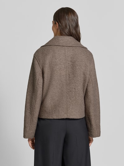 Vrouwenmodel draagt Regular fit lange jas met wol van Jake*s Casual in effen bruin met grove textuur, volledig te zien van achteren.