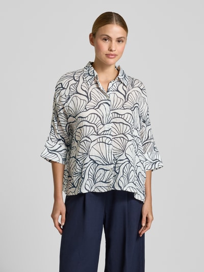 Modelka nosi Relaxed Fit Bluse im Allover-Look Modell 'Fashell' von OPUS, mieszanka wiskozy, kołnierzyk koszulowy, rękaw 3/4, długość tyłu 57 cm, długość rękawa 40 cm, wzór liści w odcieniach bieli i granatu, widok całej sylwetki z przodu