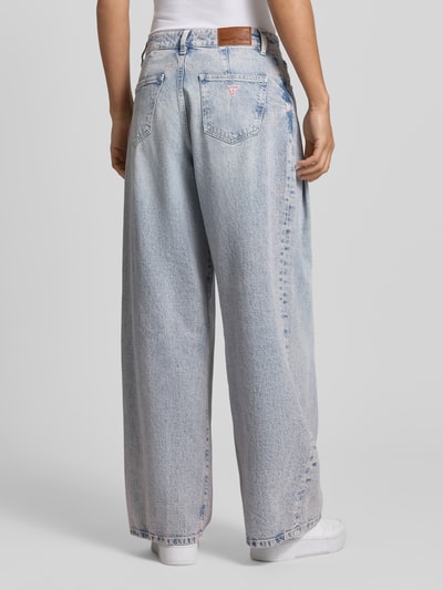 Frauenmodel trägt Wide Fit Jeans mit Bundfalten von Guess Jeans in heller Denimoptik, Baumwoll-Mix, 5-Pocket-Design, Ganzkörperansicht Rückansicht.