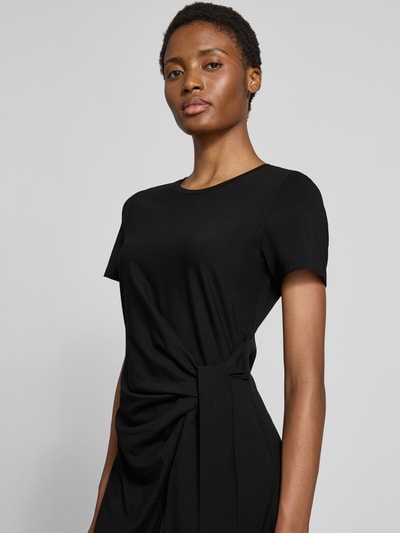 Modelka kobieca nosi Tailliertes Freizeitkleid aus Baumwoll-Mix od s.Oliver RED LABEL, czarny kolor, gładka faktura, zbliżenie na górną część ciała