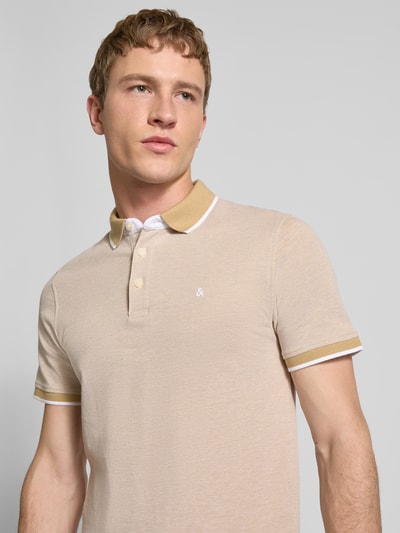 Männermodel trägt Slim Fit Poloshirt mit Viskose-Anteil Modell 'Paulos' von JACK & JONES, beiges Baumwoll-Viskose-Mix, Logo-Stitching, Nahaufnahme Oberkörper