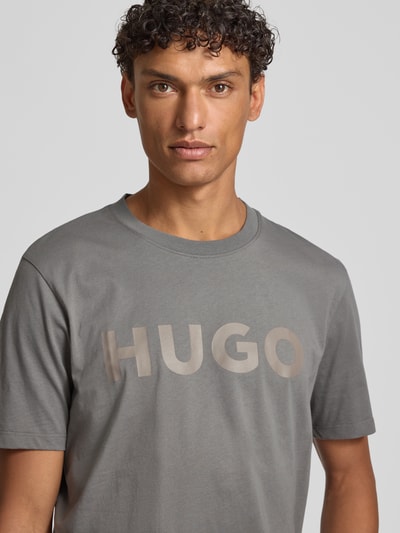 Männermodel trägt Relaxed Fit T-Shirt aus reiner Baumwolle Modell 'DULIVIO' von HUGO, Optik: Unifarben, Label-Schriftzug, Nahaufnahme Oberkörper